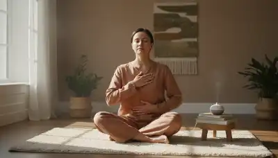 A serene, photorealistic image of a person practicing somatic regulation. They are sitting comfortably on a soft rug in a warmly lit, tranquil room with gentle morning sunlight streaming through the window. One hand is placed softly on their heart and the other on their stomach, eyes closed, breathing peacefully with an expression of profound relief. Soft earth tones, calm and healing atmosphere, high-quality editorial lifestyle photography.