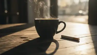 Photorealistic macro shot of a steaming cup of dark coffee next to an unlit cigarette on a wooden café table, morning sunlight creating deep shadows, evoking the strong psychological trigger and associative learning of the habit, 8k, sharp focus.