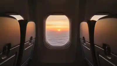 Wide, breathtaking cinematic shot from inside an airplane cabin looking out the window at a serene, minimalist sunset above a sea of clouds. The quiet, empty space in the frame evokes profound silence, peace, and the human longing for stillness. 8k resolution, highly realistic, visually soothing.