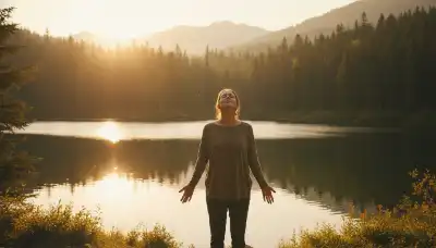 Wide photorealistic shot of a person standing at the edge of a serene mountain lake surrounded by a peaceful forest during a vibrant sunset. The person is breathing deeply, eyes closed, displaying a natural, relaxed posture of emotional balance, serenity, and resilience. Golden, warm, and comforting lighting, symbolizing a recabled mind and emotional proportion.