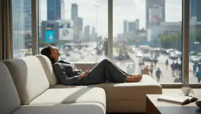 A photorealistic image of a person sitting completely relaxed on a modern living room sofa, eyes closed with a peaceful but inactive smile. Outside the large window, a vibrant, fast-paced world of movement and opportunities is visible but ignored. Soft natural indoor lighting, contrasting with the dynamic exterior, highlighting the lack of physical action.