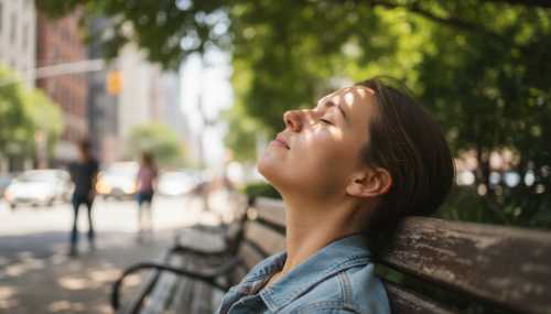 A photorealistic close-up of a person's relaxed face, eyes closed, sitting on a wooden bench in a small urban park. Soft sunlight filtering through green leaves, casting beautiful dappled shadows on their face. The background is a gently blurred city street, conveying a deep sense of biological calm amidst urban chaos.