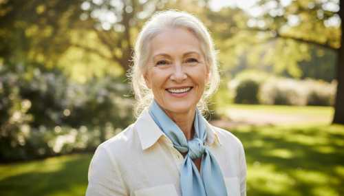 A high-end, realistic portrait of a healthy, vibrant older adult looking directly at the camera with a warm, energetic smile. They are outdoors in a bright, sunlit park. The image exudes intense vitality, health, longevity, and graceful aging. Crisp focus, bright natural lighting.