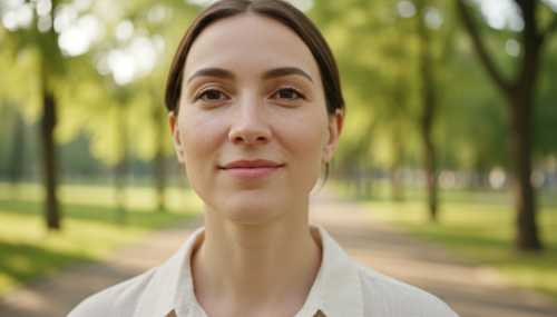 Close-up portrait of a relaxed individual walking through a tranquil urban park. No headphones, no phone in sight. They have a serene, deeply present expression, fully engaged with their natural surroundings. Soft natural daylight, highly detailed facial features, with a beautifully blurred green background.