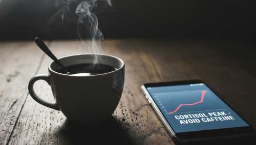 Fotografía macro fotorrealista de una taza de café negro humeante sobre una mesa de madera. La iluminación es dura y contrastada, con un smartphone encendido al lado. La composición transmite tensión sutil, representando el error de consumir cafeína durante el pico de cortisol.